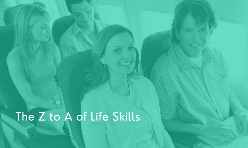 A photo of a man and a woman sitting next to each other on an airplane smiling at the nice air hostess.