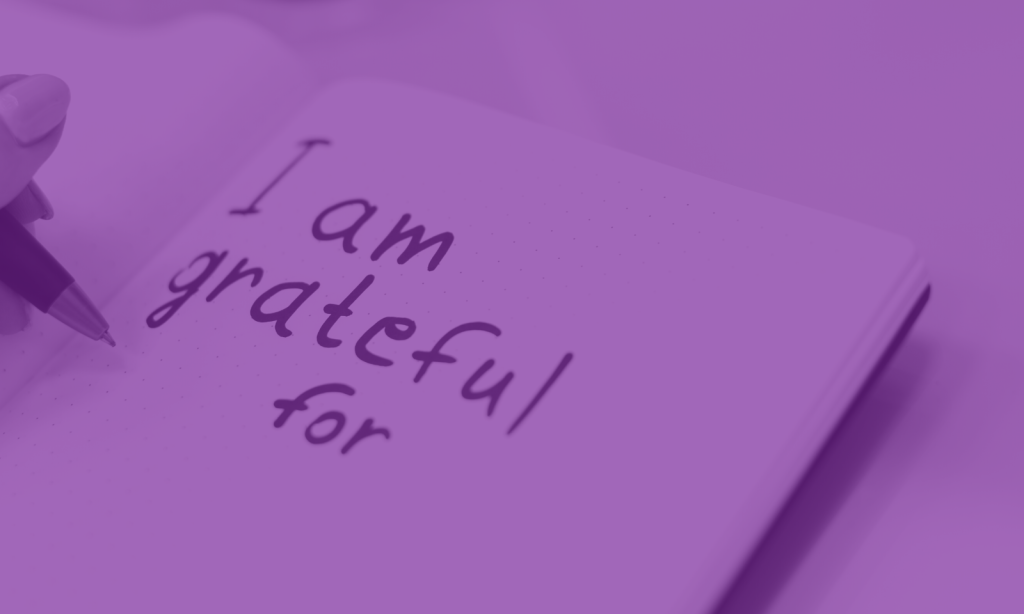 A book with the words 'I am grateful for' handwritten on the page in pen.