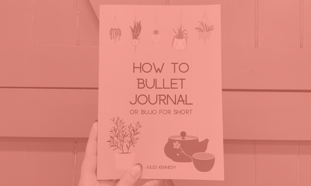 A person holding the 'How to Bullet Journal' book.