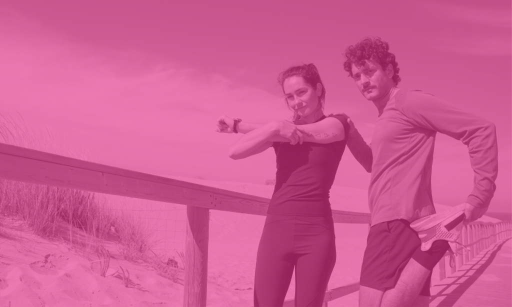 Two runners stretching by the beach.