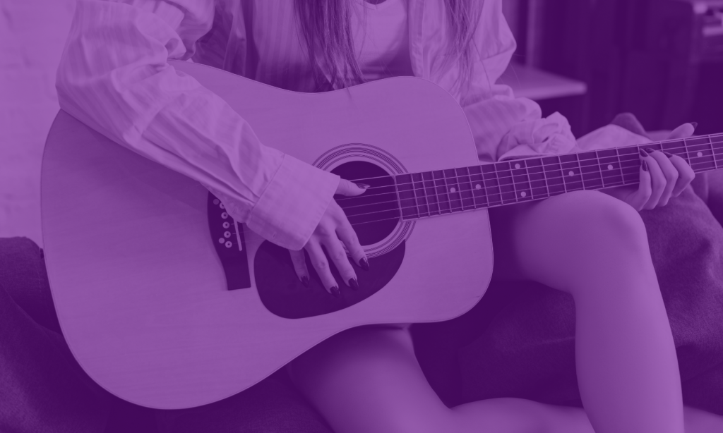 close-up of a girl holding an acoustic guitar