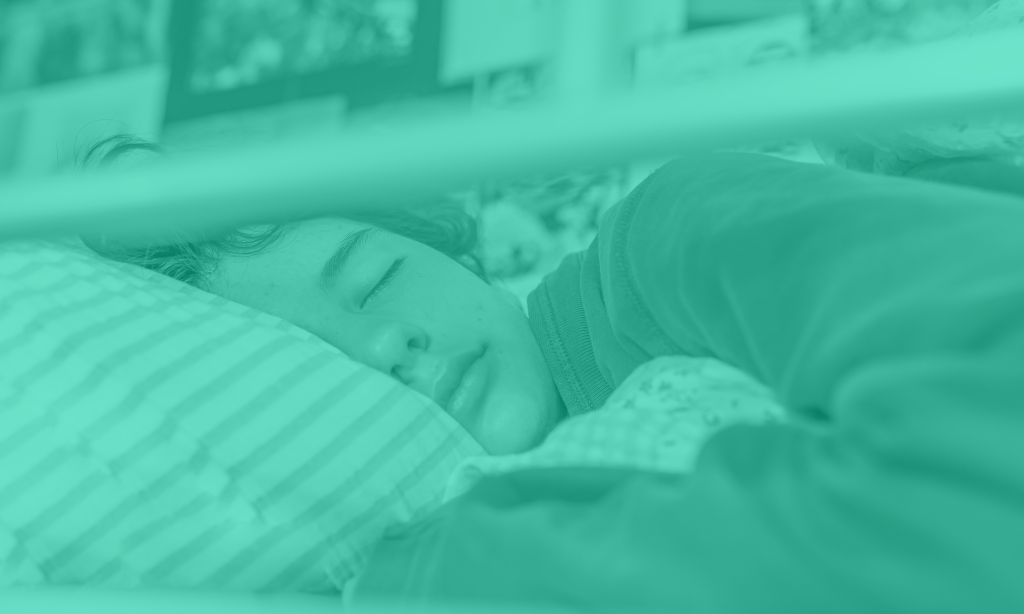 Teenage boy in a bunk bed sleeping.