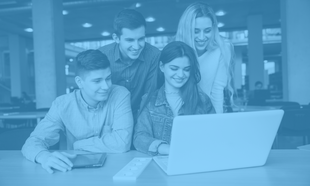 Group of students crowded around a laptop screen